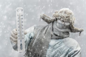 frozen-man-holding-a-thermometer-while-it-is-snowing-picture-id638381826.jpg